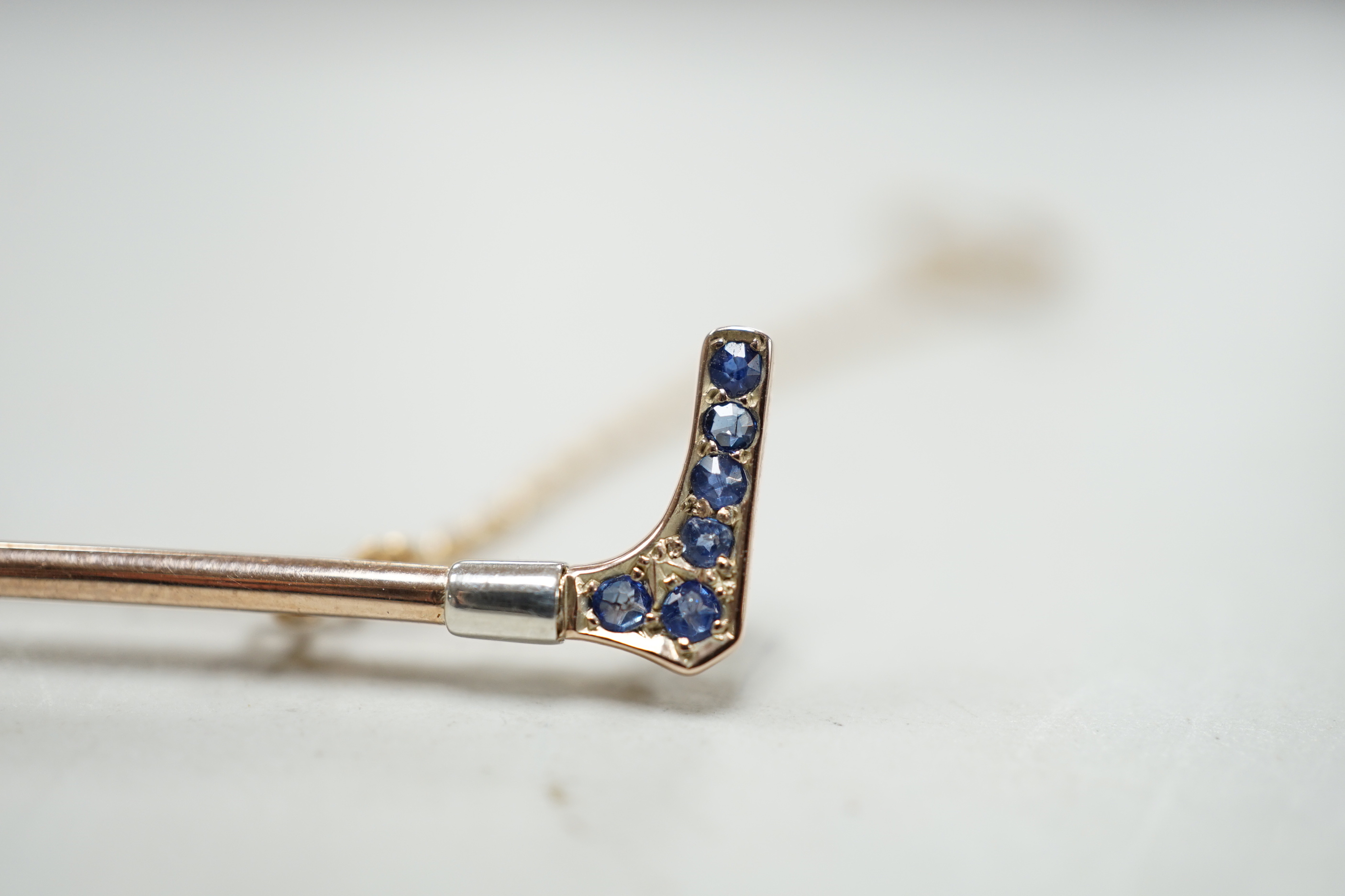 An Edwardian yellow metal, sapphire and diamond cluster fox head and riding crop bar brooch, with ruby set eyes, 52mm, gross weight 4.1 grams, in fitted box.